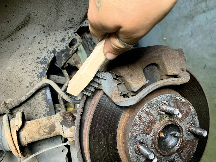 brushing off brake caliper dust and dirty 