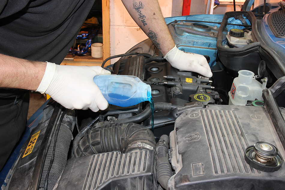 topping up engine coolant for the radiator
