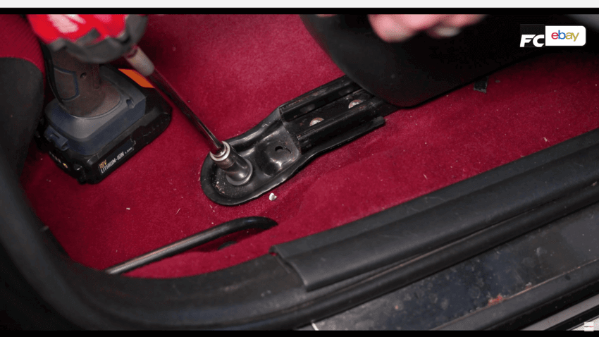 Socket undoing a bolt holding a seat into a car