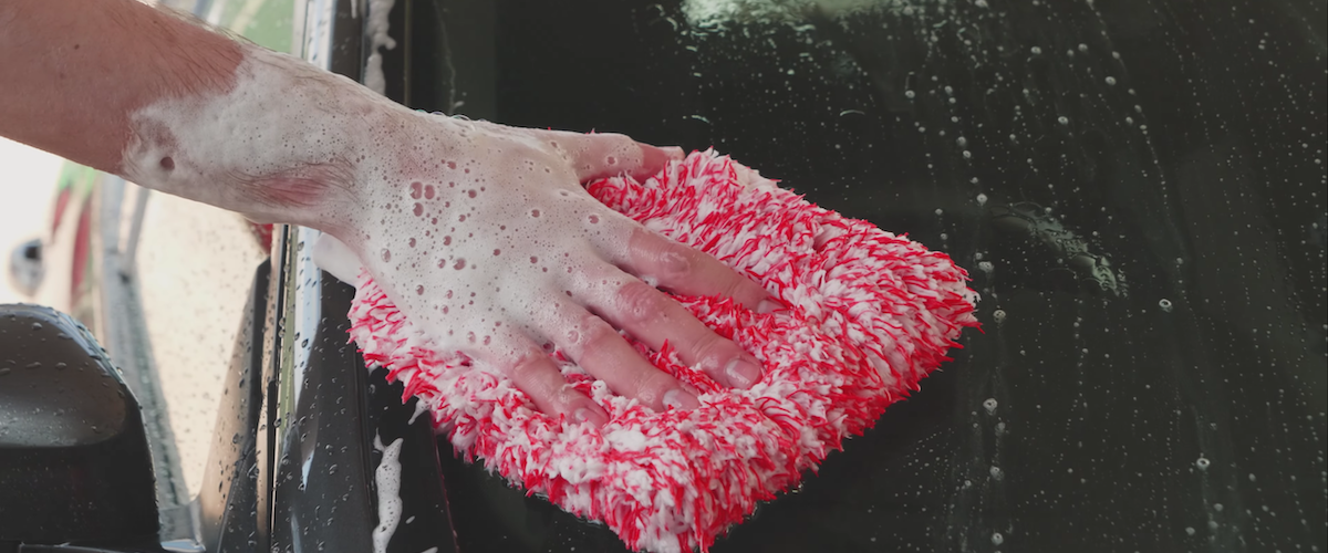 close up of wash mitt being used to wash a car