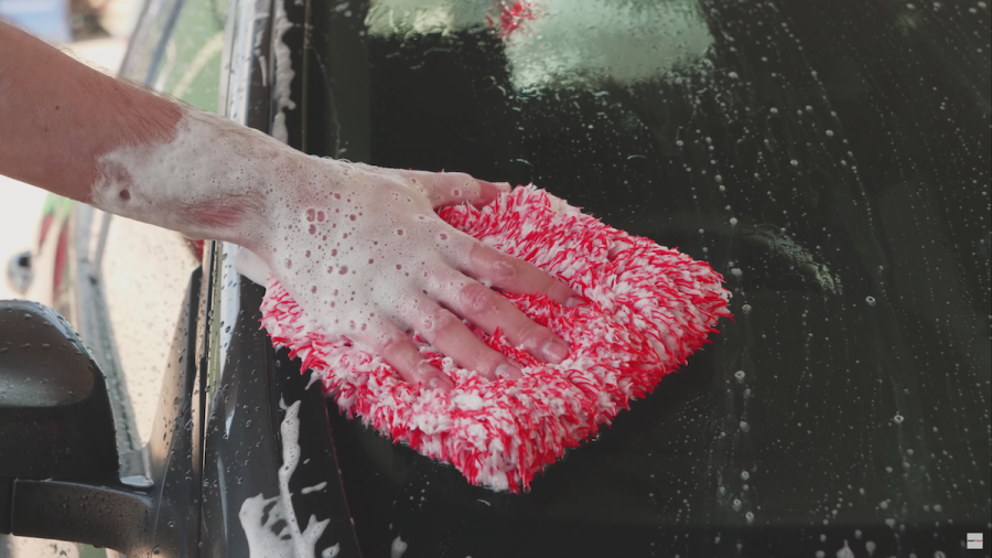 close up of wash mitt being used to wash a car