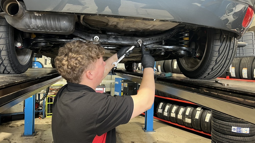 man adjusting the wheel alignment of a Ford Focus ST170