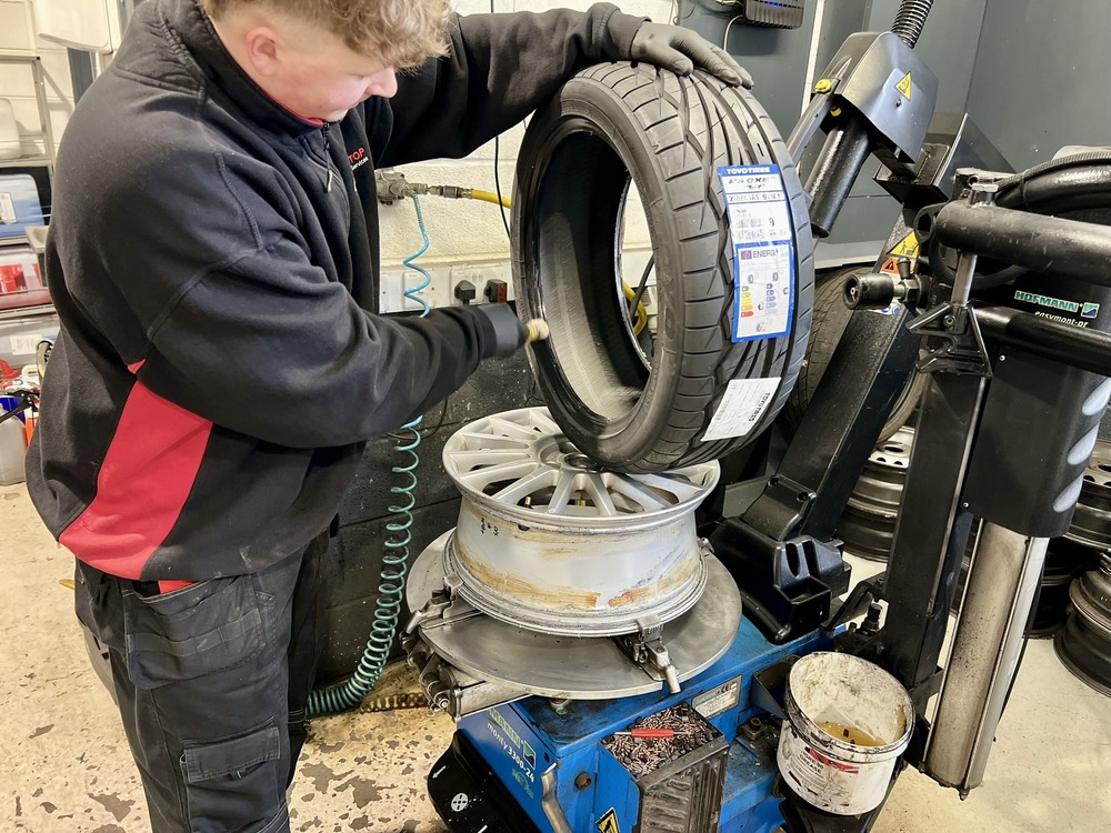 man fitting new Toyo tyre to a wheel