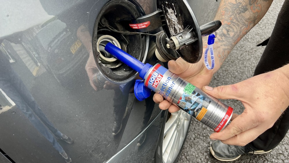 pouring fuel injector cleaner into the fuel tank of a Ford Focus ST170