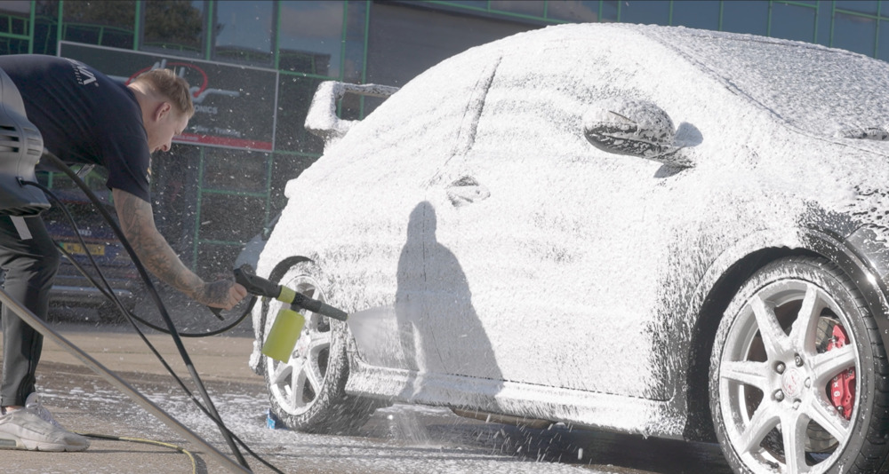 man applying snow foam to a Honda Civic