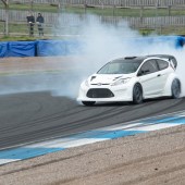 Tuned Ford Fiesta drifting at Knockhill race track with smoke coming from the tyres