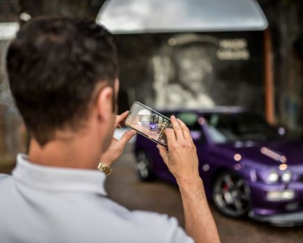 man taking photo of car