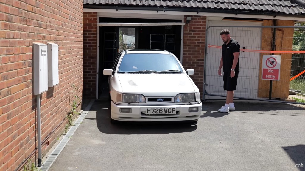 White Ford Sierra Sapphire Cosworth being driven out of a single garage