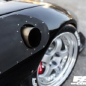 A close up of the front right wheel of a black Rotor Mazda RX 7