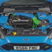 The green and blue engine inside a bright blue Ford Focus RS Mk3