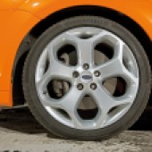 A close up of the rear right wheel of an orange Ford Focus ST Mk2
