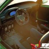 A view inside the driver's side door of a green LS-swapped BMW E30.