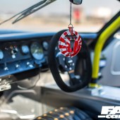 A focused shot of the red and white air freshener hanging in a Lamborghini Miura