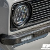 A close up of the front right headlight of a grey Ford Escort Mk2
