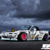 A front left side shot of a Mazda MX 5 drift car in white with stickers on the exterior
