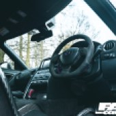 A view of the black interior in the front of a Nissan GT R