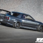A rear right shot of a grey modified Nissan Skyline R32 GT R
