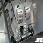 A close up of the silver foot pedals in a Mini race car