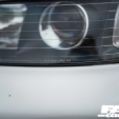 Close up of a front left headlight of a white Spoon Integra DC2