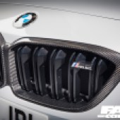 A close up of the black front grill of a white BMW M2