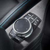 An arm rest control dial inside a white BMW M2